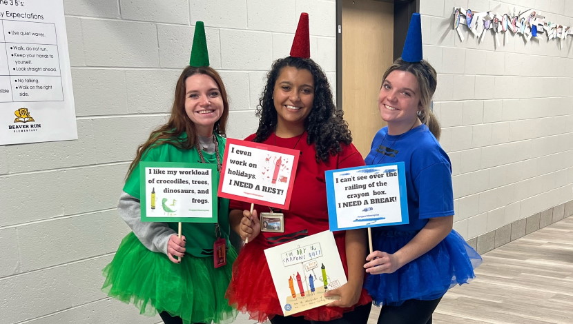 Three teachers pose for picture in costumes