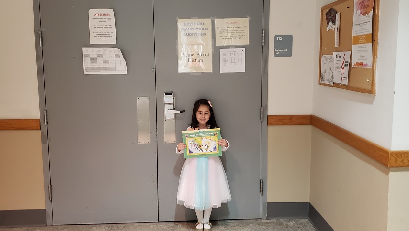 Girl standing against while holding certificate