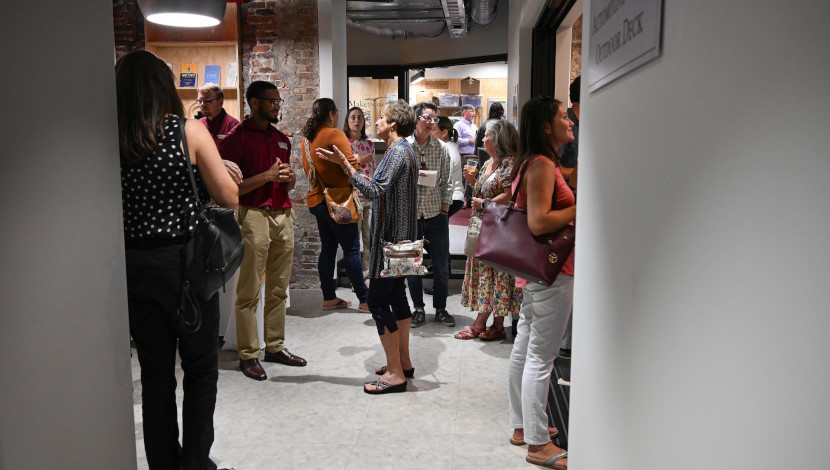 Large group of faculty stand and converse