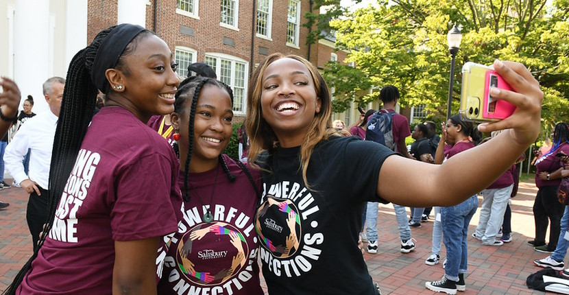 Students taking a selfie outside in front of Holloway Hall