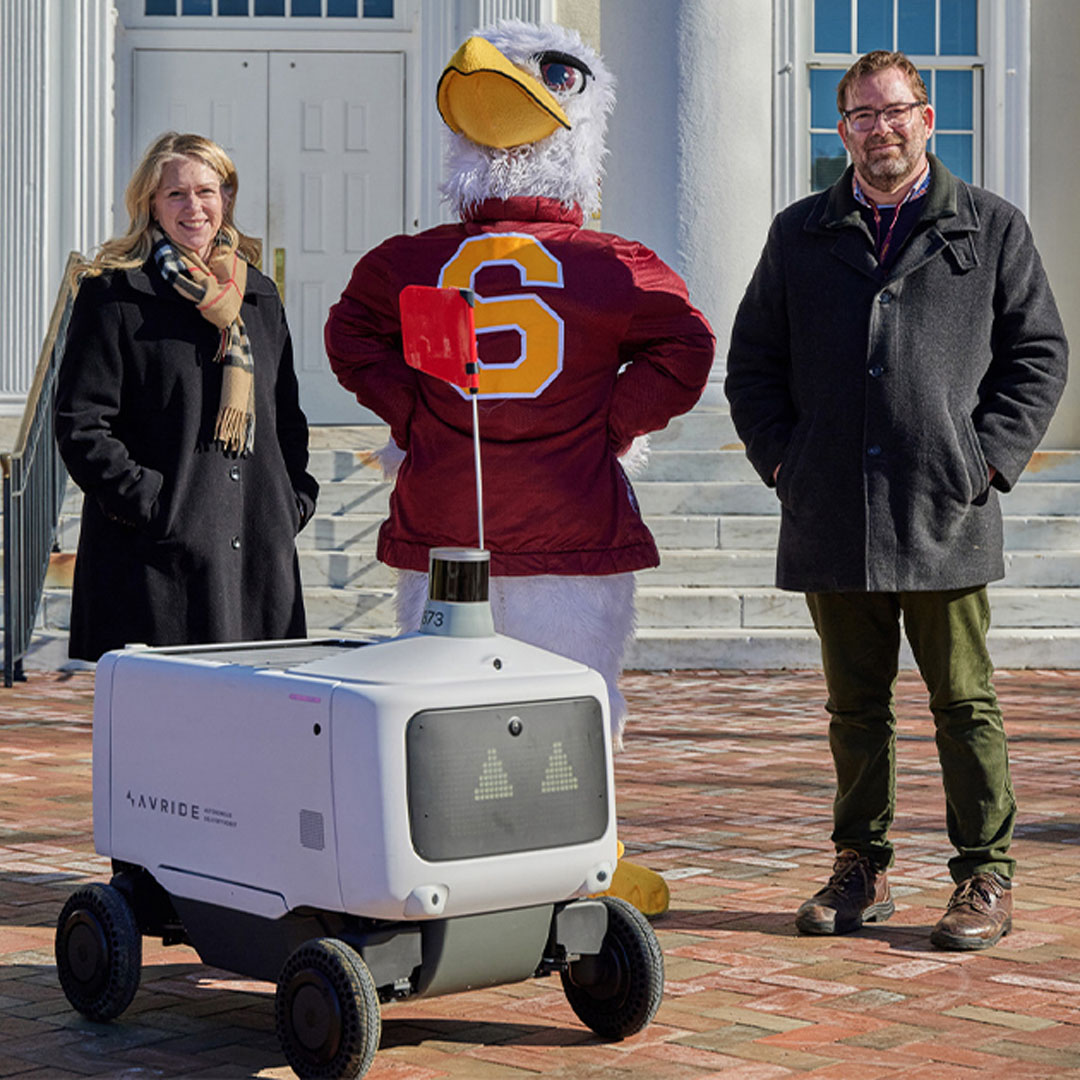 SU President Carolyn Ringer Lepre and Food Service Director George Oakley with an Avride food delivery robot